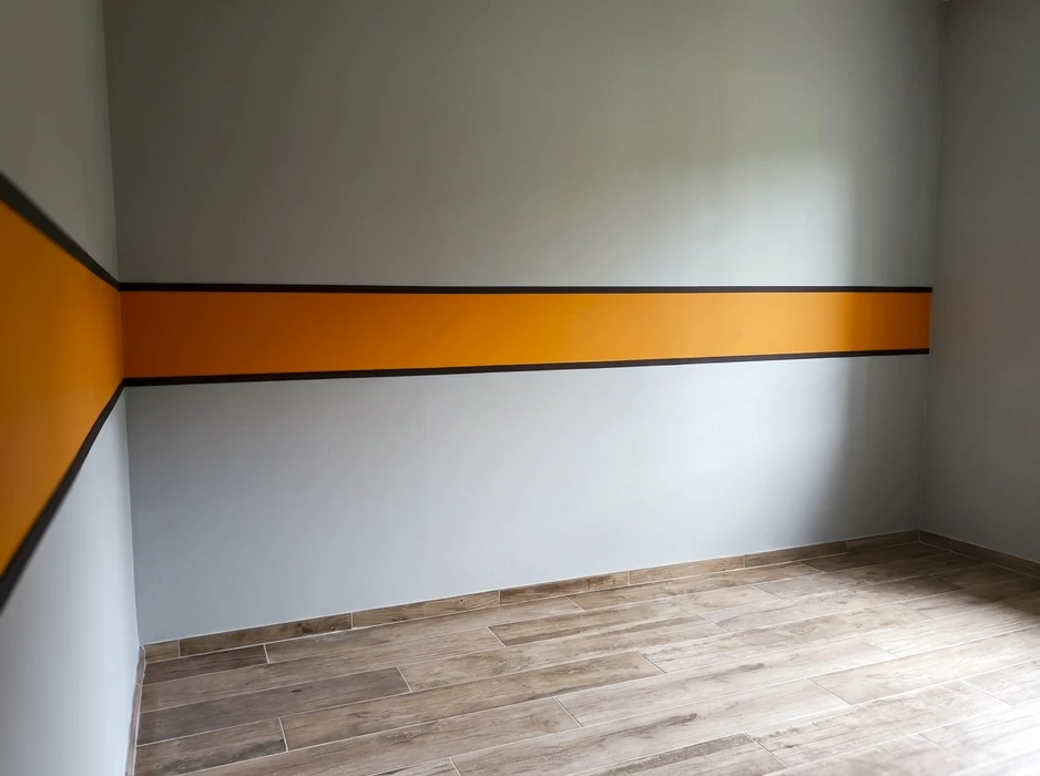 Femme choisissant la couleur de peinture parfaite pour sa chambre avec un peintre et décorateur professionnel, elle tient des nuances de couleurs